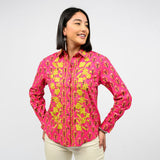 Woman wearing a pink floral embroidered shirt on a white background