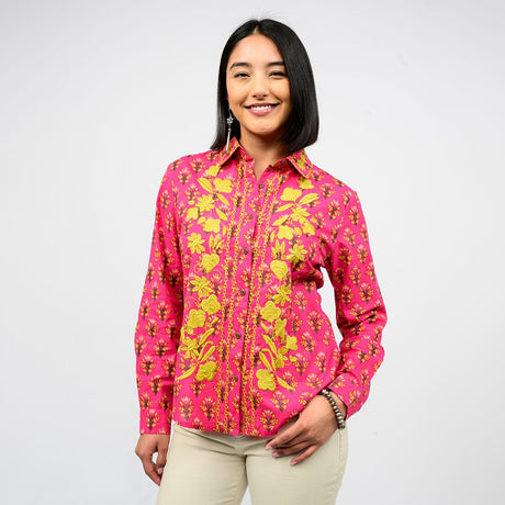 Woman wearing a pink floral embroidered shirt on a white background