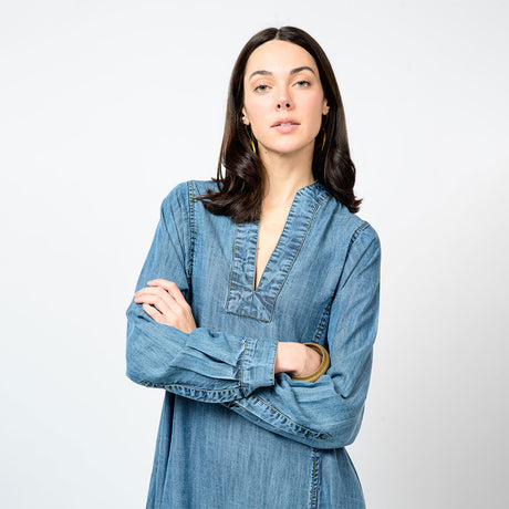 Woman wearing a denim dress against a plain background