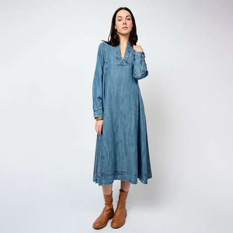 Woman wearing a blue denim dress with long sleeves on a white background