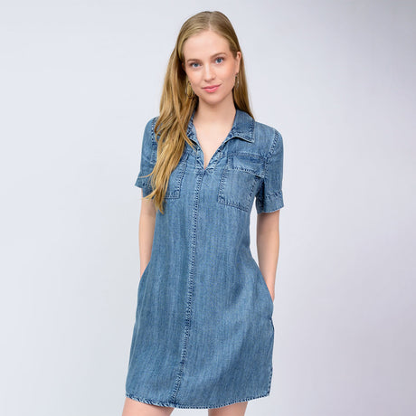 Woman wearing a denim dress against a plain background
