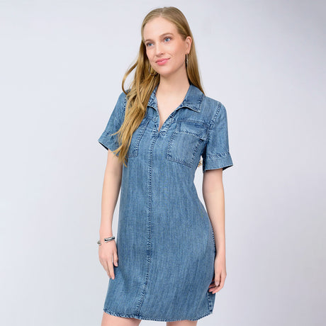 Woman wearing a denim dress against a plain background
