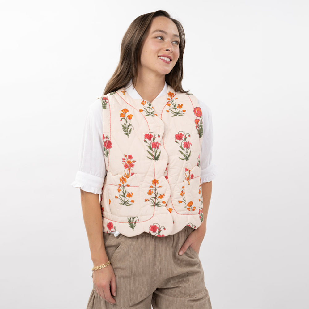 Woman wearing a floral embroidered vest on a white background