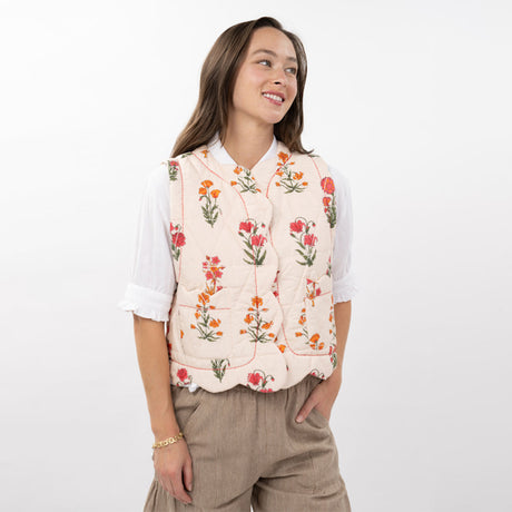 Woman wearing a floral embroidered vest on a white background