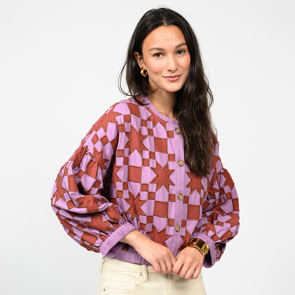 Woman wearing a patterned blouse with a white background