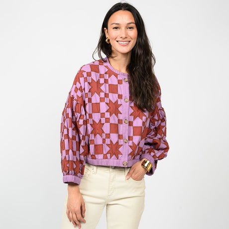 Woman wearing a patterned jacket on a white background