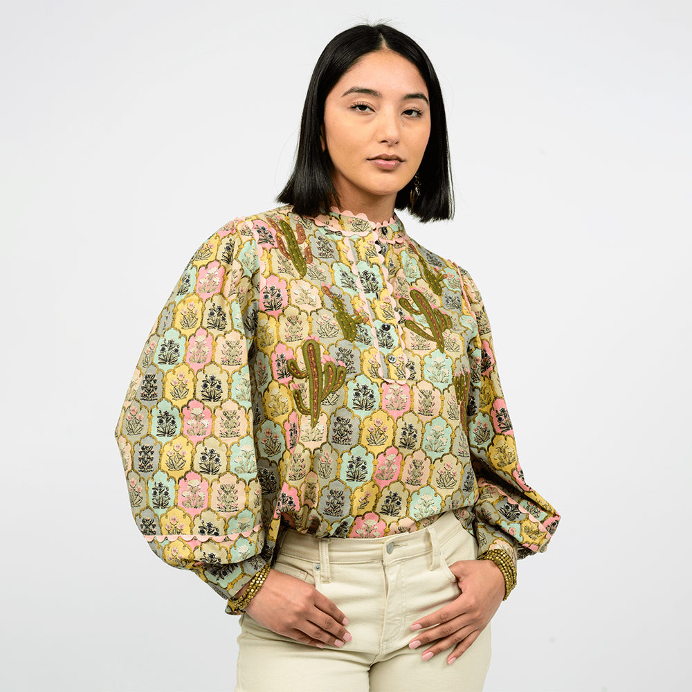 Woman wearing a patterned blouse with a white background