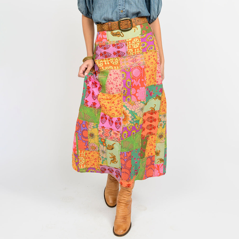 Person wearing a colorful patchwork skirt with a white background