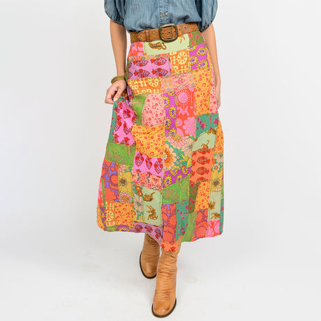 Person wearing a colorful patchwork skirt with a white background