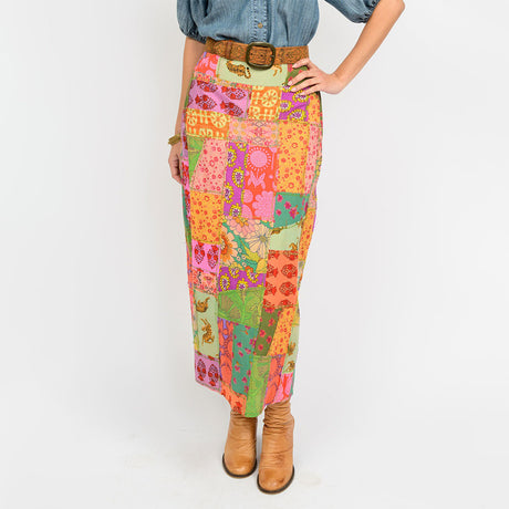 Person wearing a colorful patchwork skirt with a white background