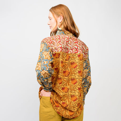 Person wearing a colorful patterned shirt on a plain background