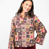 Woman wearing a colorful patterned jacket on a white background
