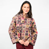 a woman wearing a multi colored pullover  with burgundy pants