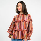 Woman wearing a striped blouse with ruffled details on a white background