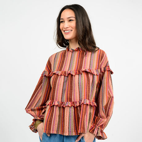 Woman wearing a striped blouse with ruffled details on a white background