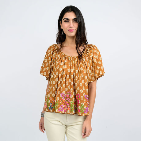 Woman wearing a floral blouse with a plain background