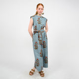Woman wearing a blue jumpsuit with floral embroidery on a white background