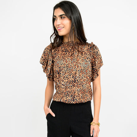 Woman wearing a leopard print top with ruffled sleeves on a white background