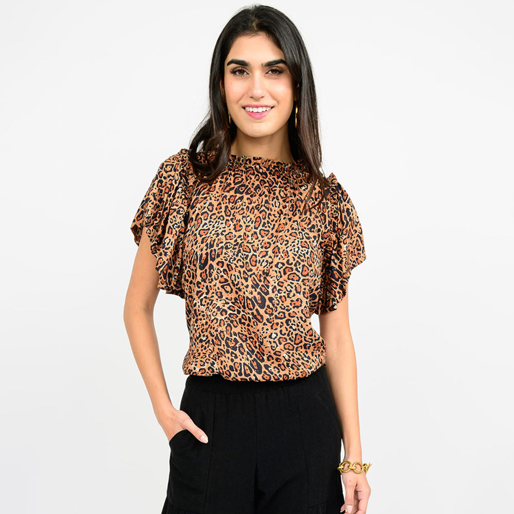 Woman wearing a leopard print top on a plain background