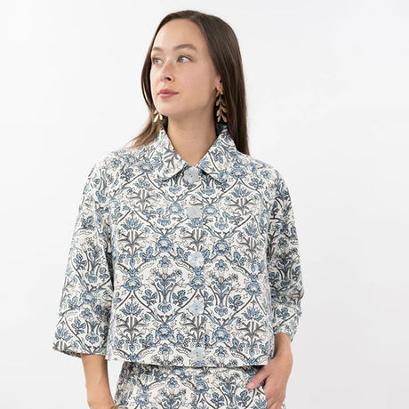 Woman wearing a floral patterned shirt on a white background