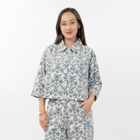 Woman wearing a floral pajama set on a white background