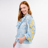 Woman wearing a floral blouse with blue and yellow patterns on a white background