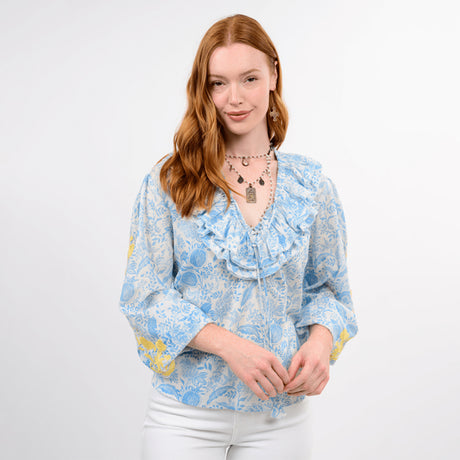 Woman wearing a blue floral blouse against a white background