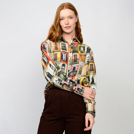 Woman wearing a colorful patterned shirt against a plain background