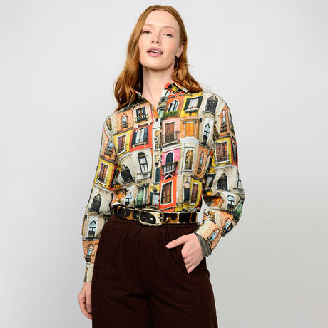 Woman wearing a colorful patterned shirt with a plain background