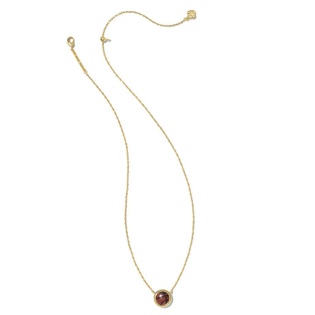 A delicate gold chain necklace with a small oval pendant featuring a reddish-brown stone surrounded by a gold border, displayed on a clean white background.
