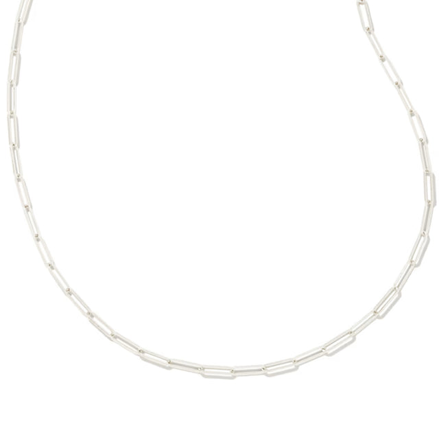 A silver paperclip link chain necklace displayed in a curved shape against a solid white background.