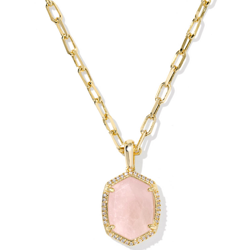 Gold necklace with a pink pendant on a white background