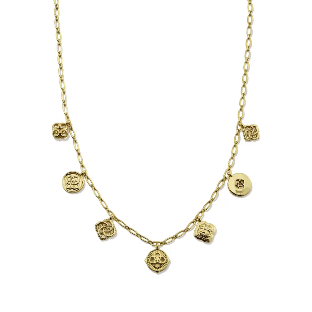 A gold chain necklace featuring multiple small dangling charms, including round medallions and textured floral or skull-like motifs, shown on a plain white background.
