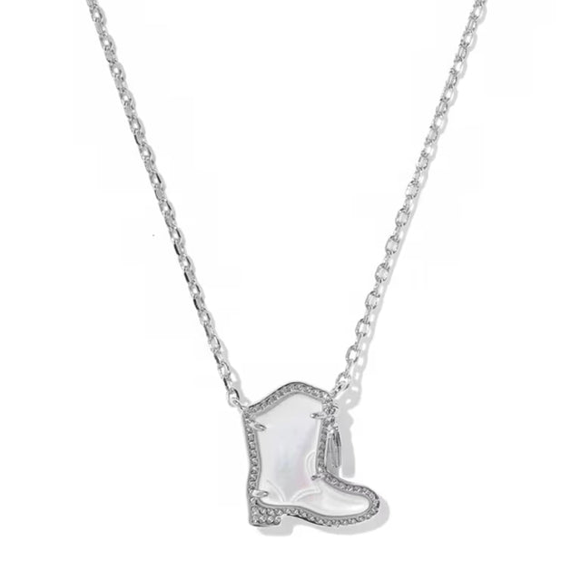 A silver-toned necklace featuring a cowboy boot pendant with a white iridescent inlay and small clear stones along the edges, shown against a plain white background.