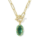 A gold paperclip chain necklace with a toggle clasp and a dangling green marquise-shaped gemstone pendant, shown on a clean white background.
