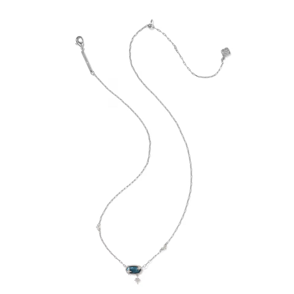 A delicate silver chain necklace featuring a small rectangular dark blue gemstone pendant and a tiny silver cross charm below it, displayed on a solid white background.