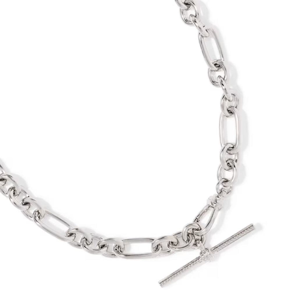 A silver-toned chain necklace featuring a mix of classic Figaro and oval links, with a polished T-bar clasp adorned with a small clear crystal, shown on a clean white background.