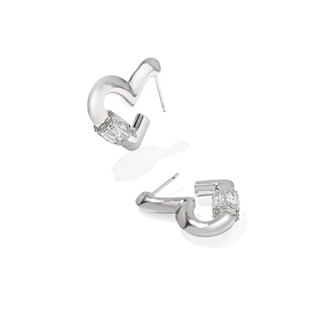 A pair of silver-toned C-shaped hoop earrings with a clear rectangular gemstone at the front, shown on a clean white background.