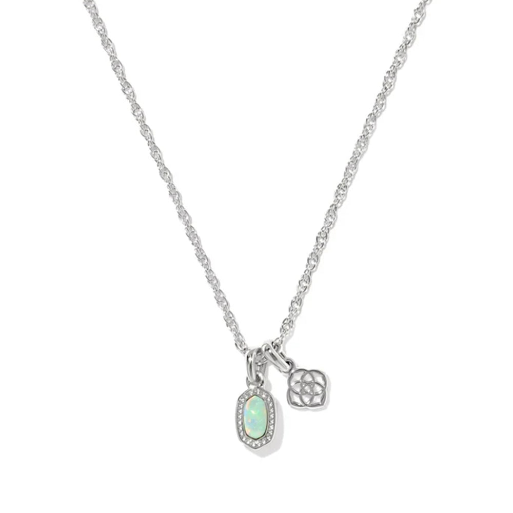 A silver chain necklace featuring an oval pendant with a light green opal-like center surrounded by small clear stones, alongside a small geometric charm, shown on a plain white background.