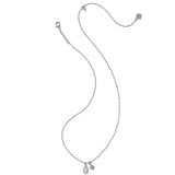 A delicate silver-toned chain necklace with a small oval light green gemstone pendant and a tiny matching stone accent, displayed on a solid white background.