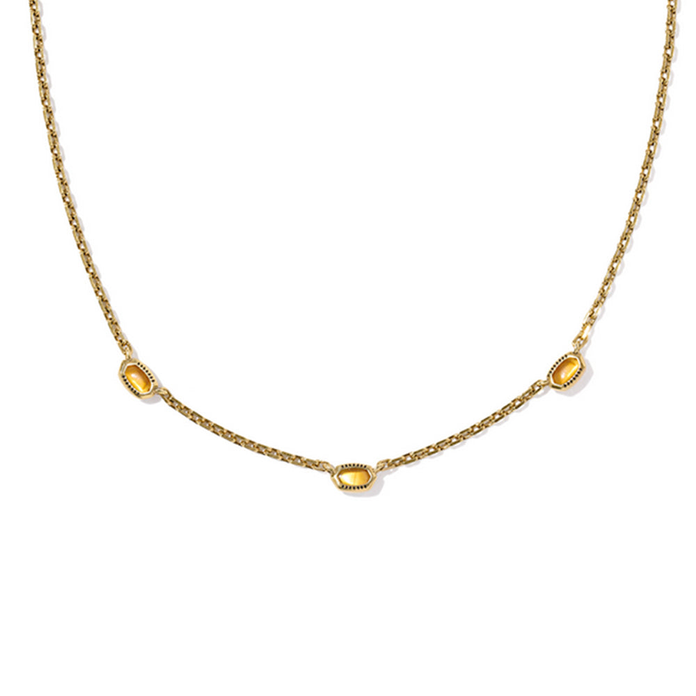 Gold necklace with three yellow gemstones on a white background