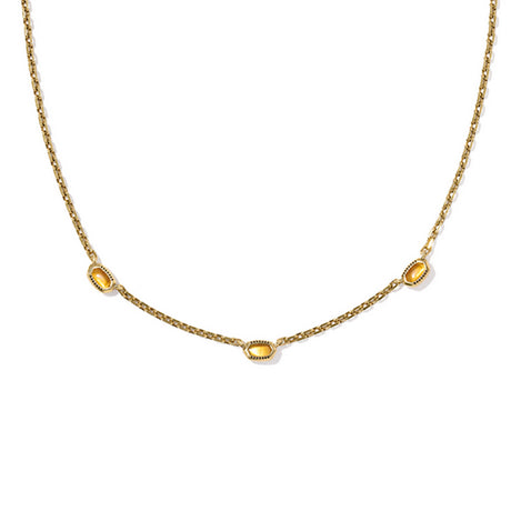 Gold necklace with three yellow gemstones on a white background