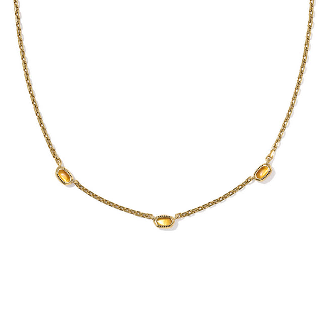 Gold necklace with three yellow gemstones on a white background