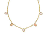 A gold chain necklace featuring five small, oval-shaped pink cabochon gemstones set in gold bezel settings, arranged symmetrically on a plain white background.