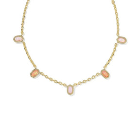 A gold chain necklace featuring five small, oval-shaped pink cabochon gemstones set in gold bezel settings, arranged symmetrically on a plain white background.