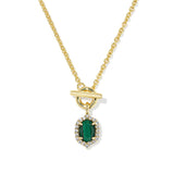 A gold chain necklace with a toggle clasp and a pendant featuring a green emerald-cut center stone surrounded by small clear stones, shown on a white background.
