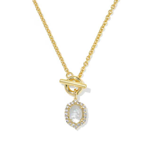 A gold chain necklace with a toggle clasp and a teardrop-shaped pendant featuring a small carved figure surrounded by clear stones, shown on a plain white background.