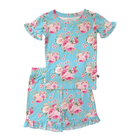 A two-piece girls' pajama set featuring a short-sleeve top and matching shorts in light blue with a pink and white floral rose print, displayed on a solid white background.