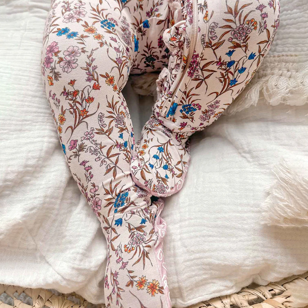 Floral-patterned baby romper on a textured surface