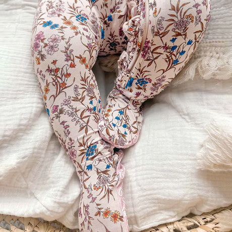 Floral-patterned baby romper on a textured surface